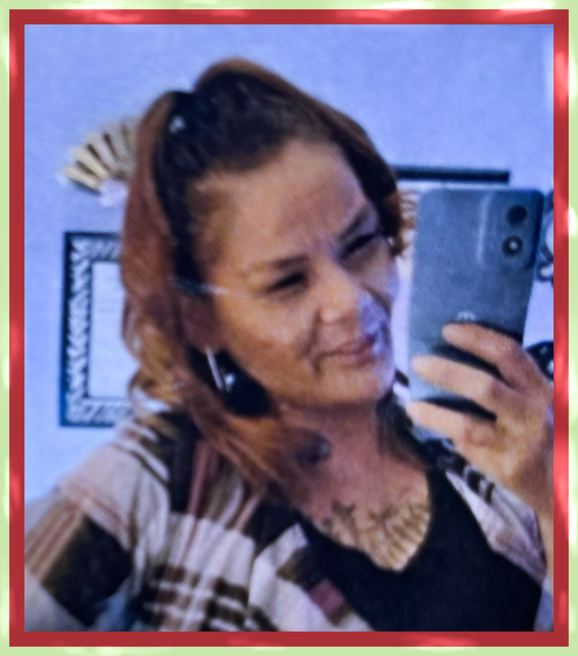 Camey DuBois Young woman wearing casual clothes,in a selfie where she's looking into her phone to make sure the mirror caught her smiling, happy, standing confidently